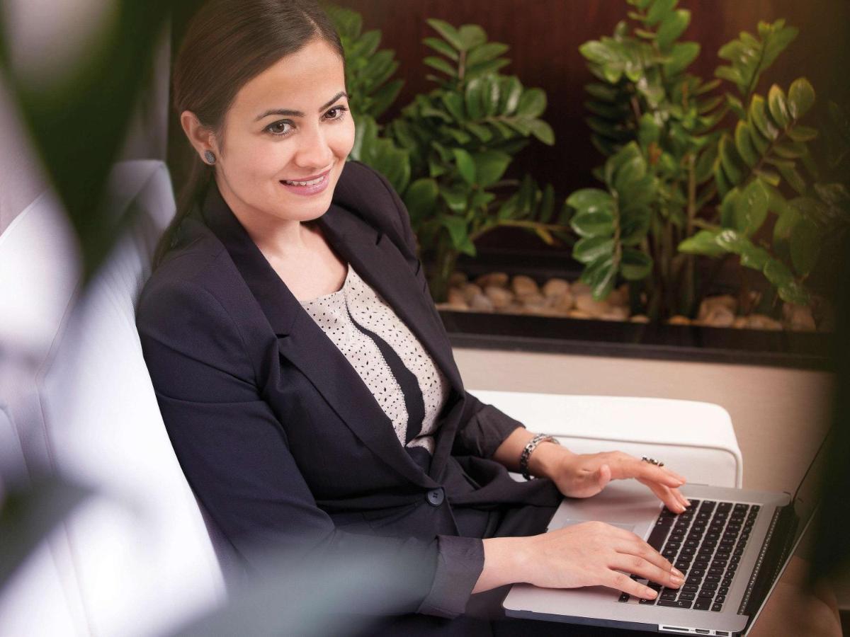 Movenpick Jumeirah Village Triangle Dubaï Extérieur photo A business woman working on a laptop